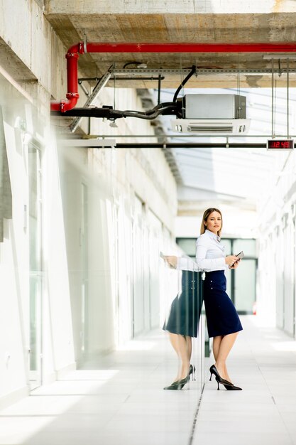 young-woman-working-digital-tablet-office-hallway_52137-48173